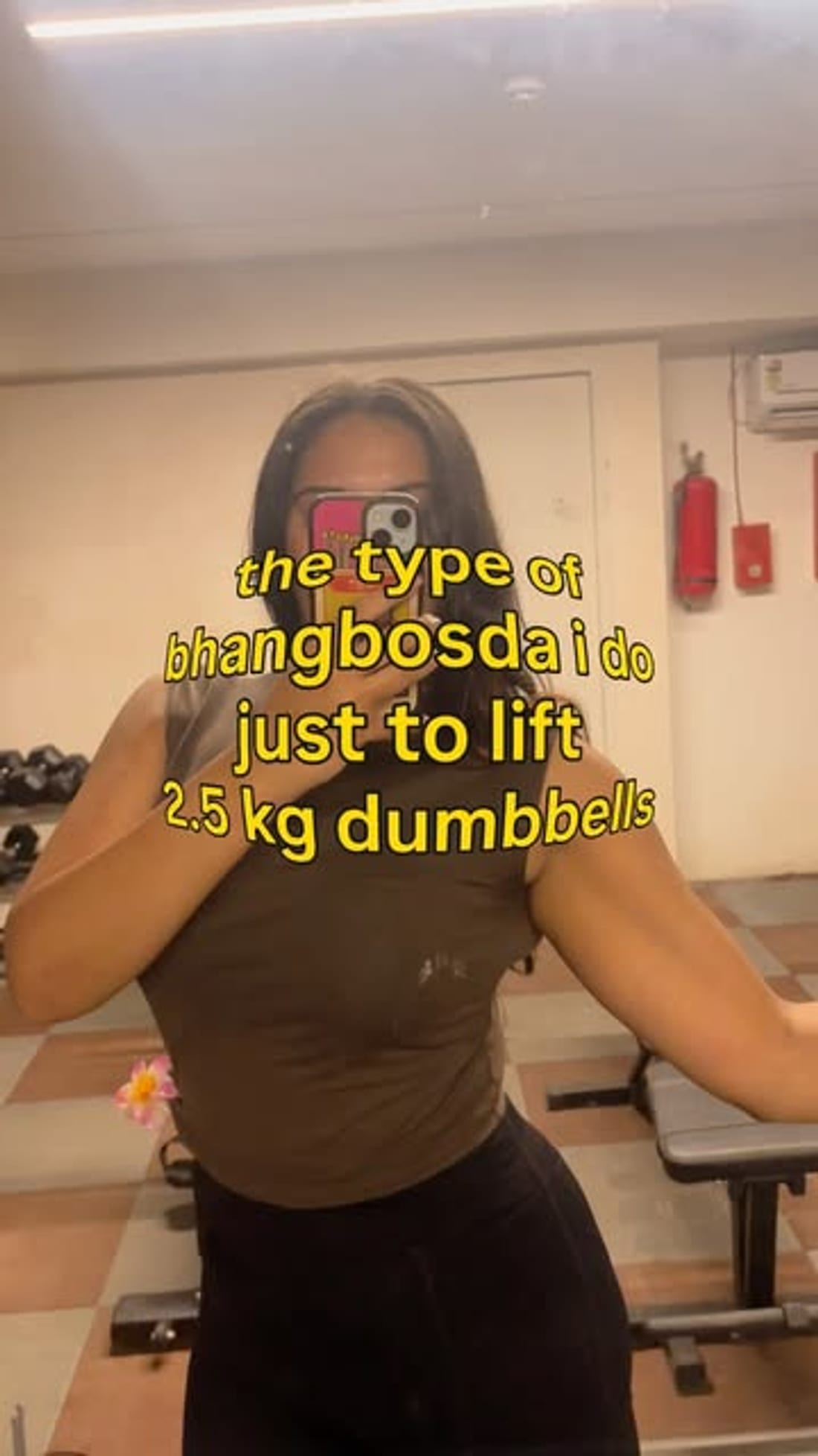 Gym mirror selfie captioned about lifting 2.5kg dumbbells