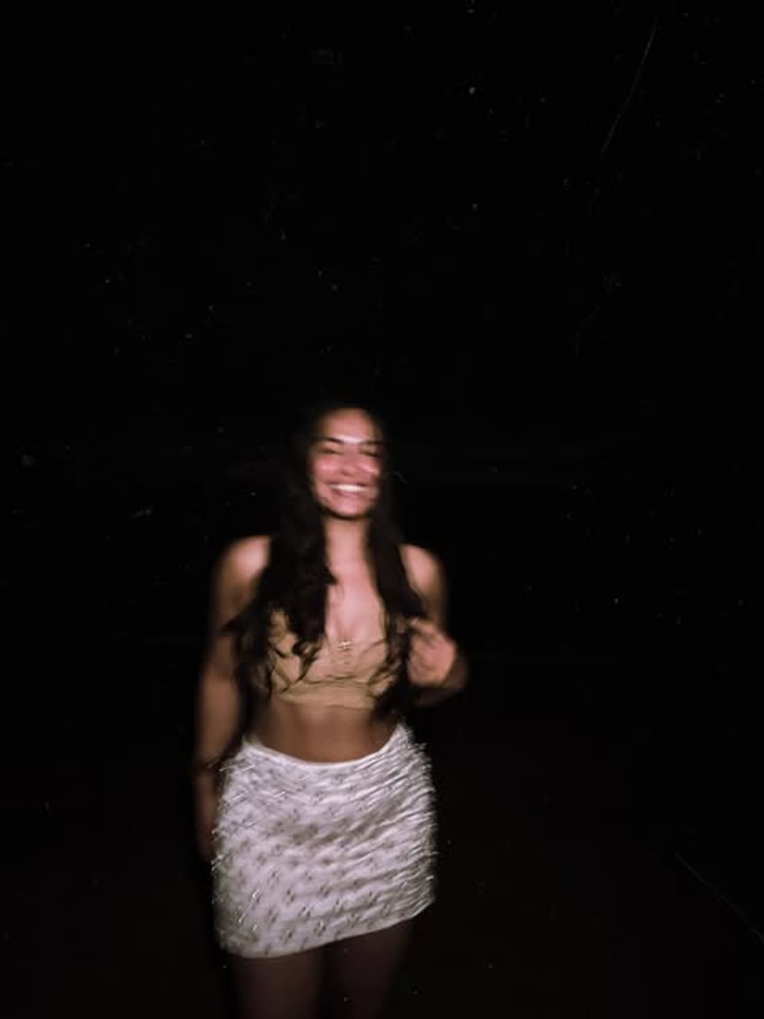 Standing outdoors at night under trees